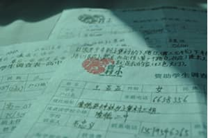 一张手写的学生情况调查表摊在桌面上,盖有学校红章